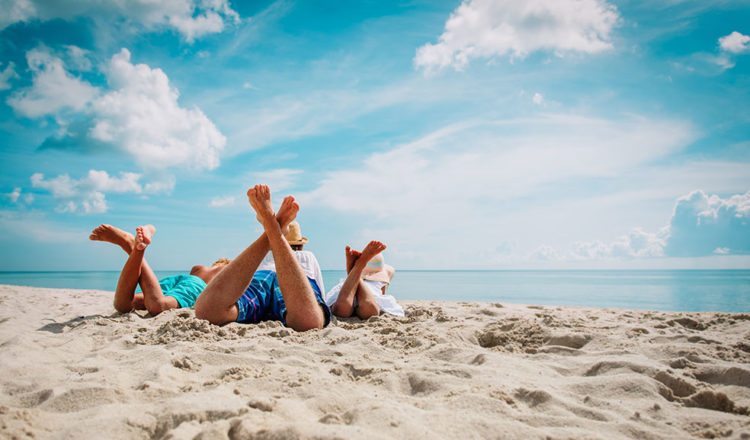 Vacances !! famille allongée sur le sable